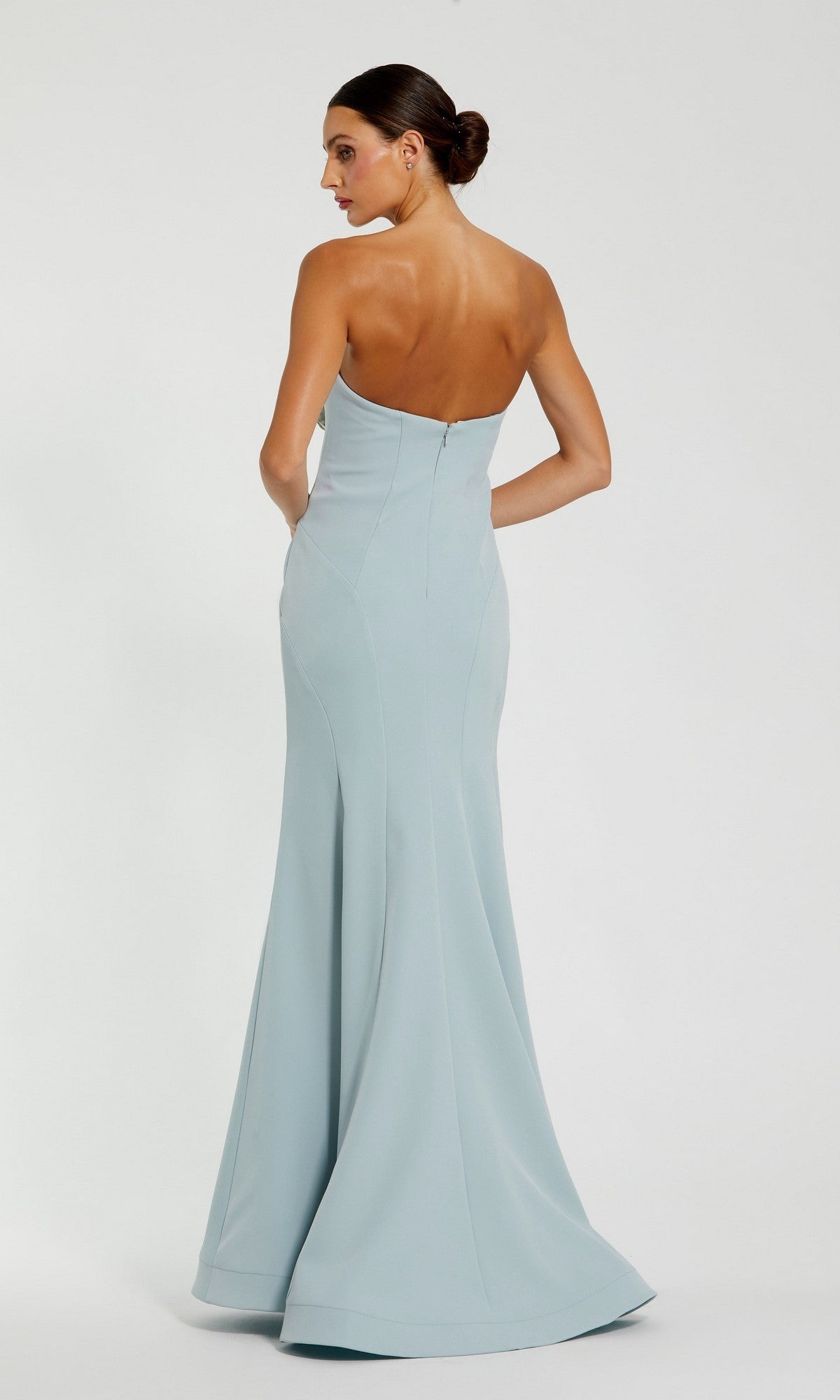 A woman stands with her back to the camera against a plain background, wearing the Mac Duggal 11855 Strapless Floral Formal Gown in light blue.